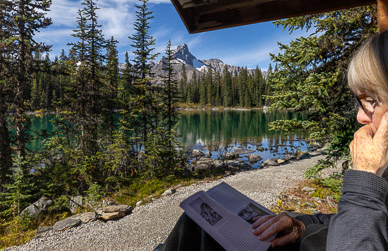 Reading on our front porch, Cathedral Mountain in background