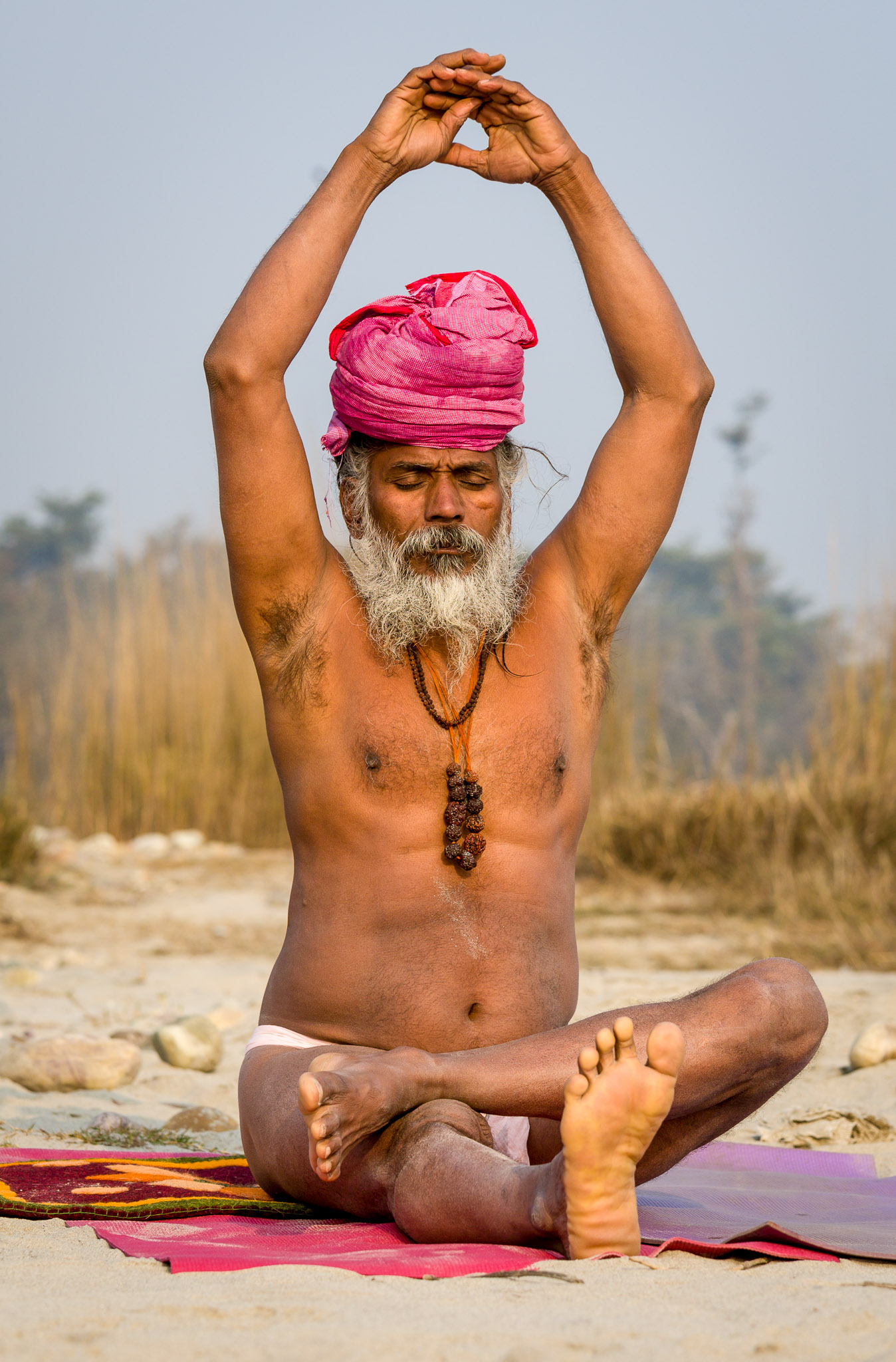 Yogi practicing yoga along the Ganges